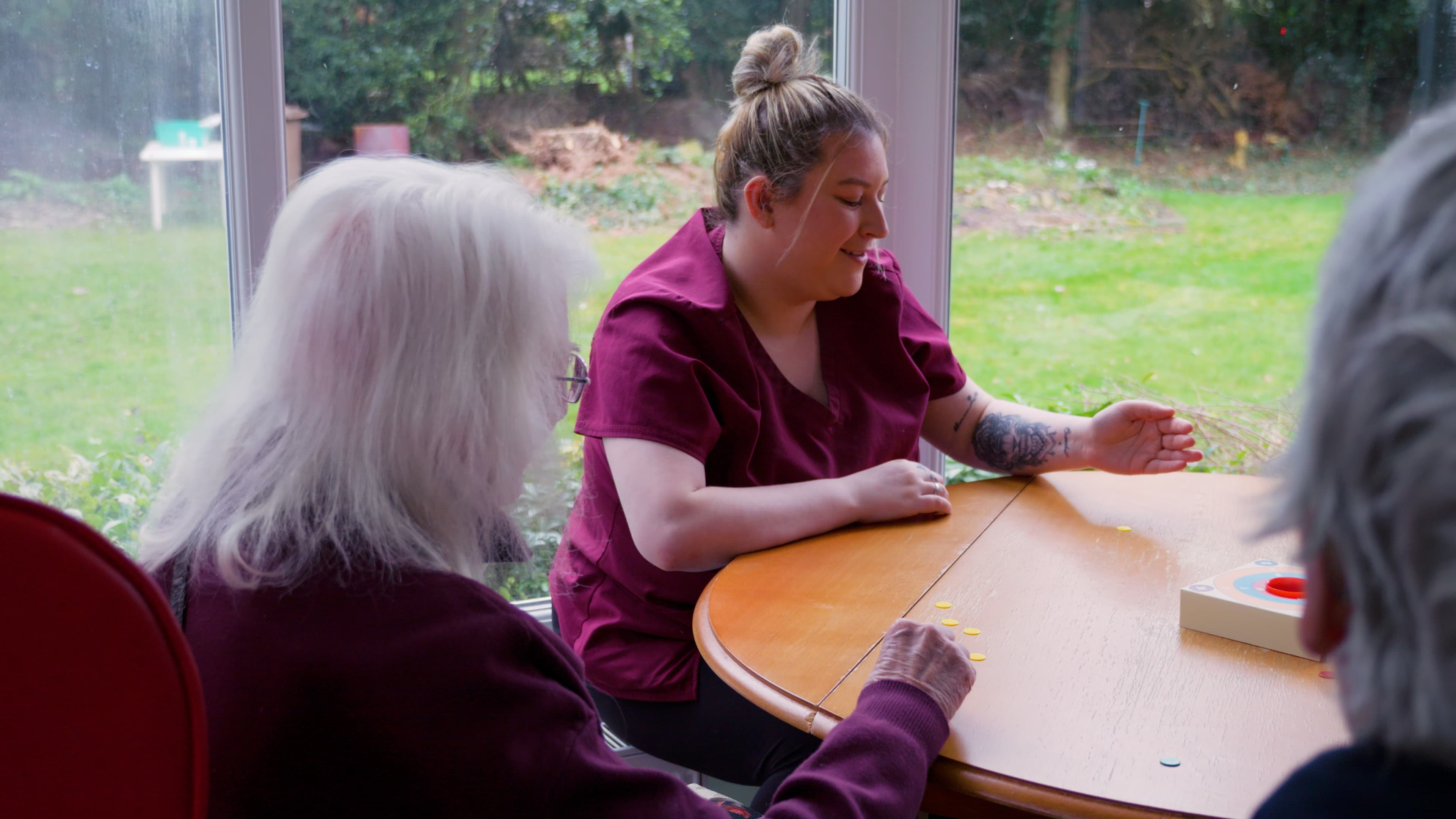 A carer playing a game with residents at Canwick House